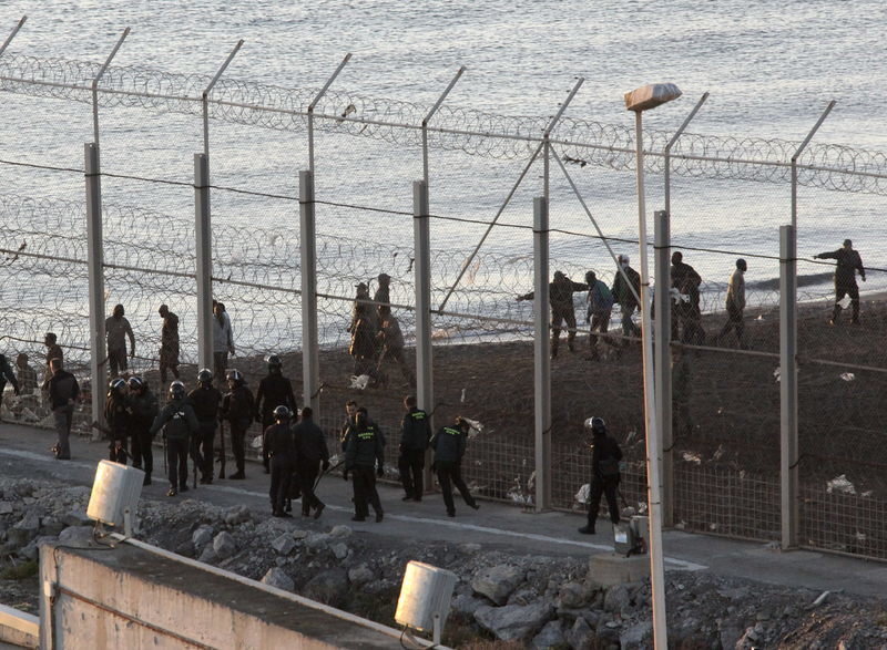 Un grupo de inmigrantes sin papeles intenta entrar en España rodeando la valla de Ceuta hasta el mar.