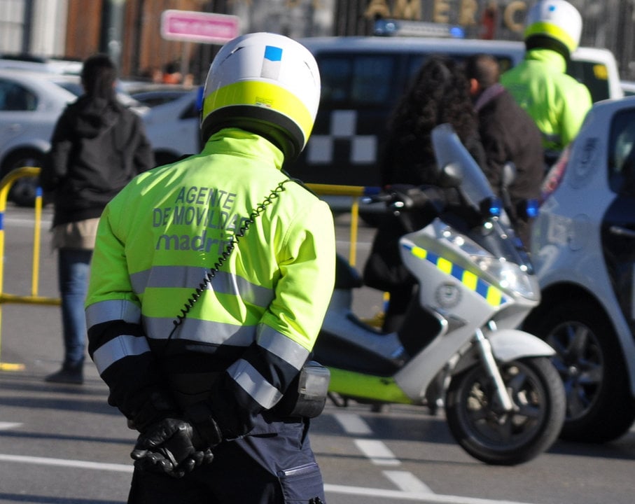Varios agentes de movilidad controlan el tráfico en una calle de Madrid.
