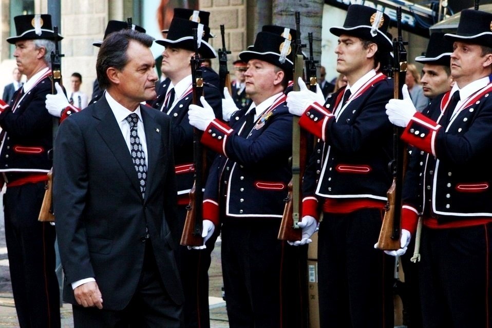 Artur Mas pasa ante varios agentes de los Mossos d'Esquadra vestidos de gala.