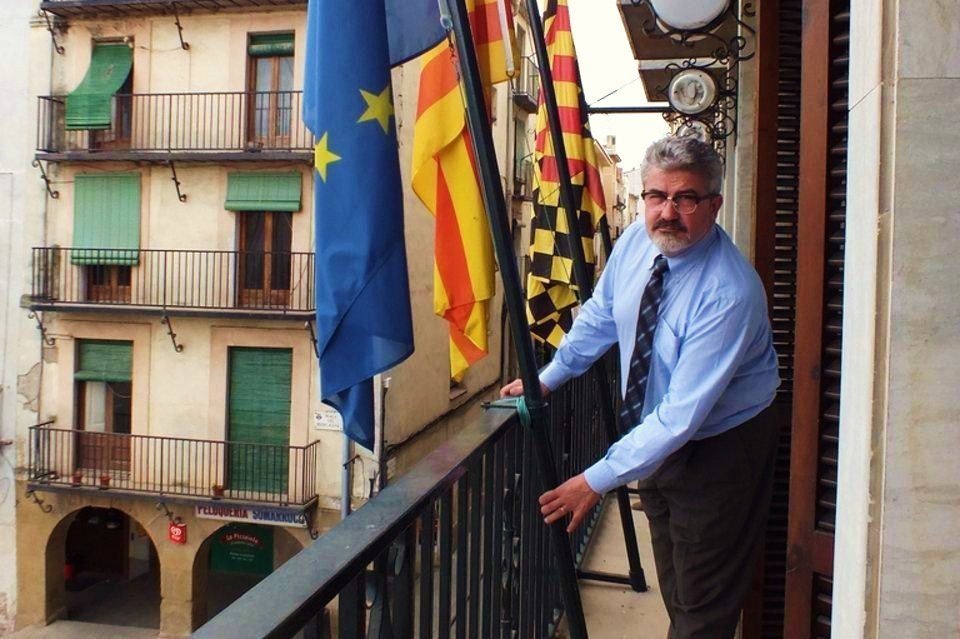 El alcalde de Balaguer (Lérida), Josep María Roigé, junto a las banderas municipal, de Cataluña y de la UE.