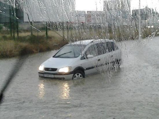 Un vehículo intenta circular durante la fuerte tormenta en Yecla