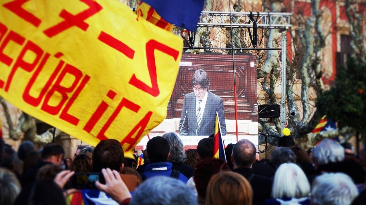 Independentistas siguen en una pantalla gigante la investidura de Puigdemont.