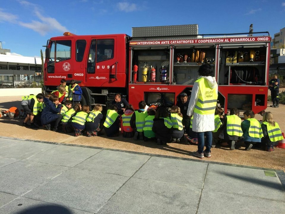 Niños junto a un camión de bomberos.