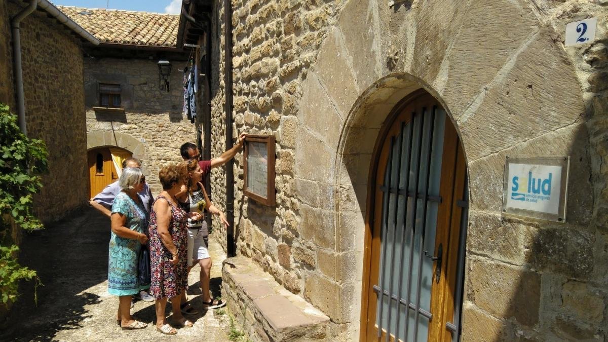 Vecinos de Urriés consultan el horario provisional del médico en la puerta del consultorio