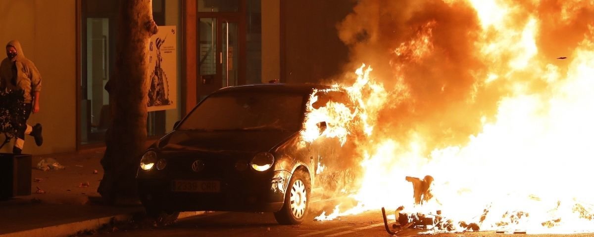 Un coche arde durante los disturbios que se están produciendo tras la concentración este miércoles de miles de personas ante la conselleria de Interior en Barcelona  EFE  Andreu Dalmau