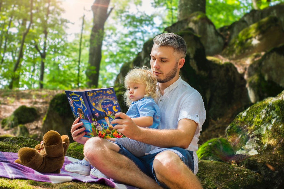 Un hombre lee un libro a una niña.