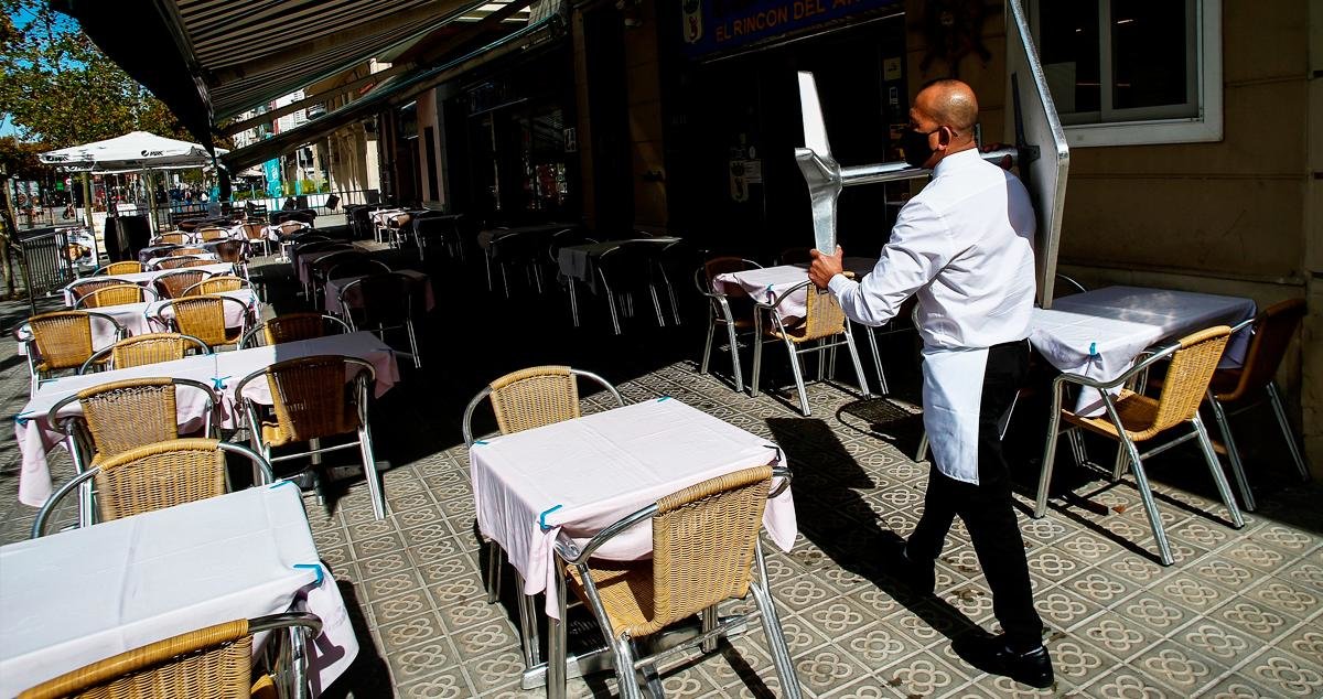 Un camarero porta una mesa en un restaurante en el centro de Barcelona.