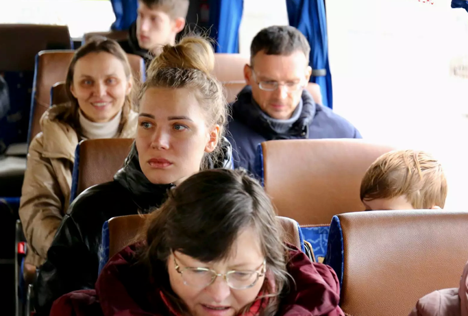 Varias personas a bordo de un autobús llegan a la sede de REMAR en Madrid