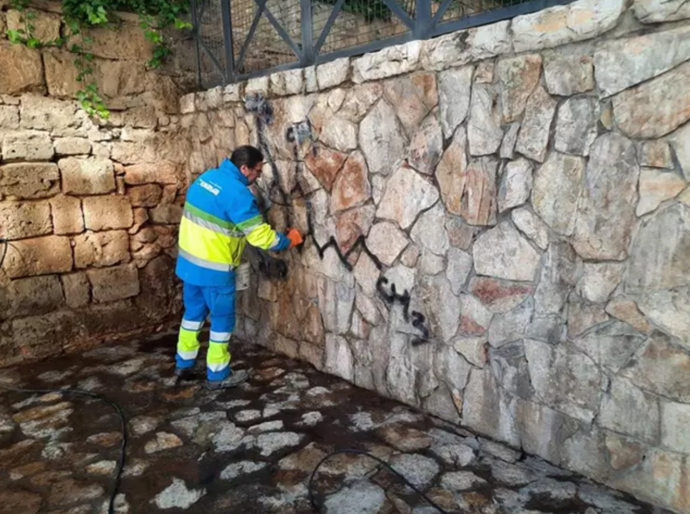 Un operario de Emaya limpia una pintada vandálica en las escaleras de la plaza Mediterrànea.