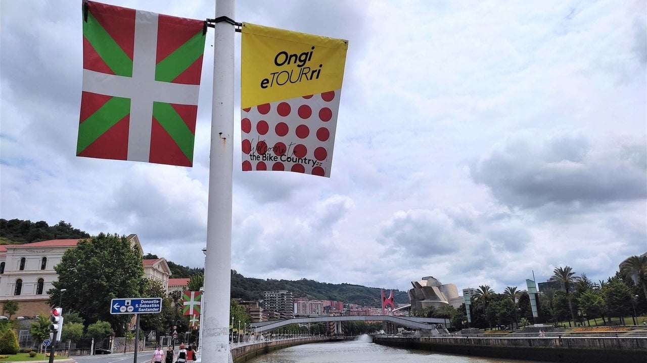 La ikurriña luciendo frente a una bandera del Tour de Francia en las calles de Bilbao. 