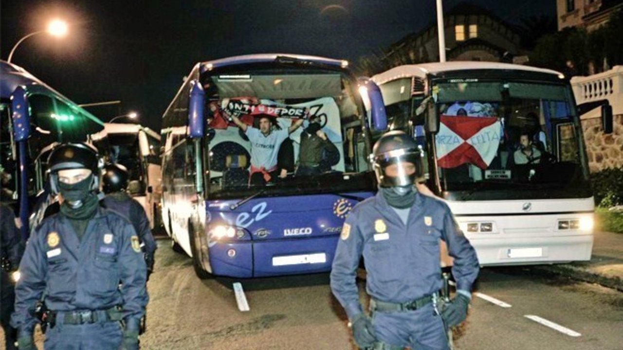 Agentes de la Policía Nacional escoltan dos autobuses de hinchas del Celta de Vigo en un derbi con el Deportivo de La Coruña.