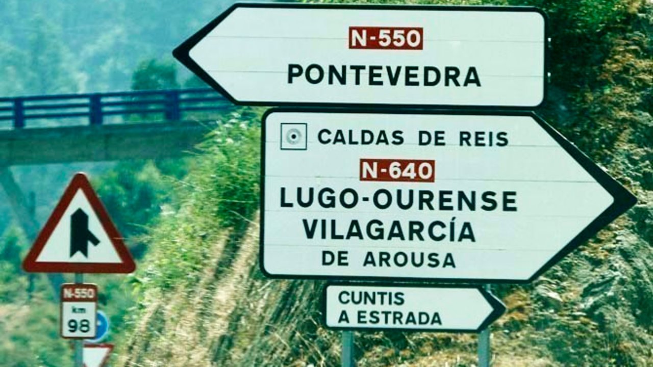Señales de carretera con los municipios en gallego.