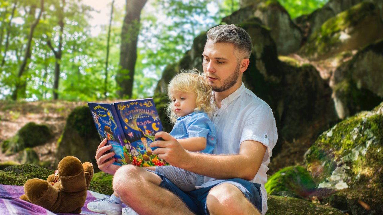 Un hombre lee un libro a una niña.