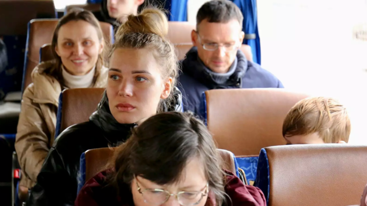 Varias personas a bordo de un autobús llegan a la sede de REMAR en Madrid