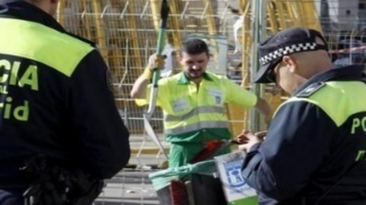 Dos policías municipales de Madrid escoltan a un barrendero que cumple los servicios mínimos.