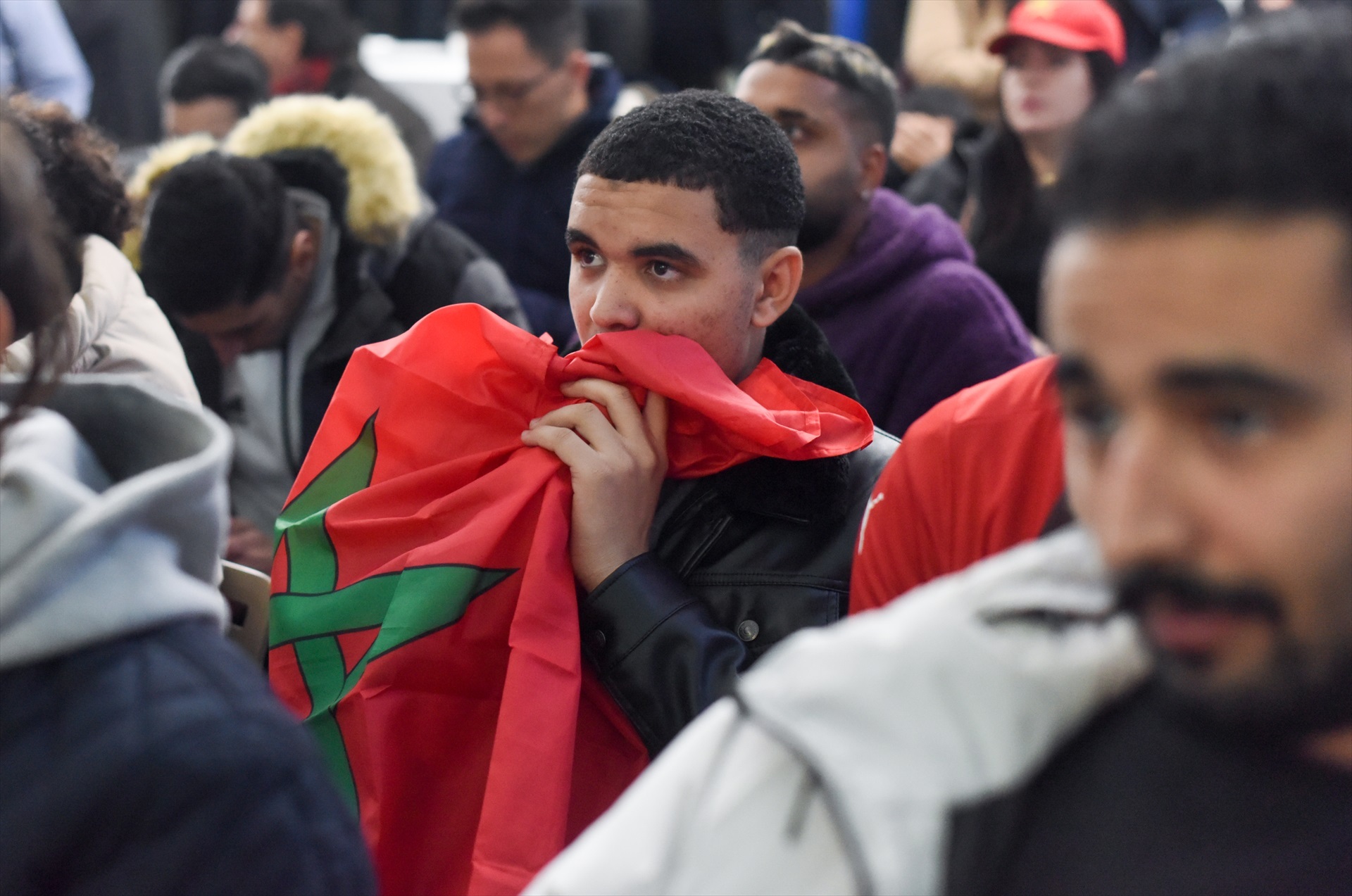 Un aficionado con la bandera de Marruecos en la Casa Árabe observa el partido España-Marruecos.