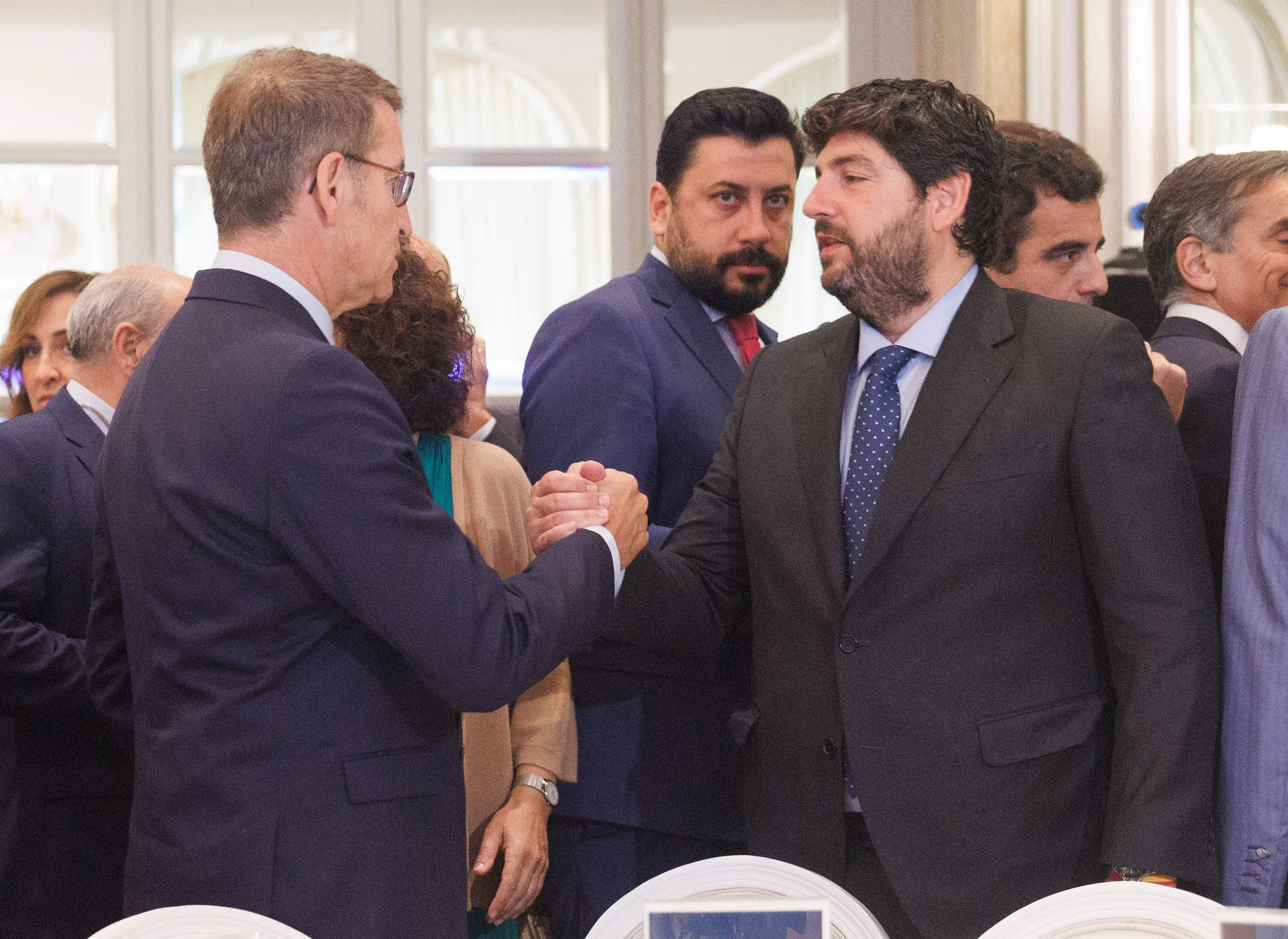 El líder del Partido Popular, Alberto Núñez Feijóo (i), saluda al presidente del Gobierno de Murcia en funciones, Fernando López Miras (d), a su llegada a un desayuno informativo de la tribuna Fórum Europa, en el Hotel Mandarin Oriental Ritz, a 19 de junio en Madrid.